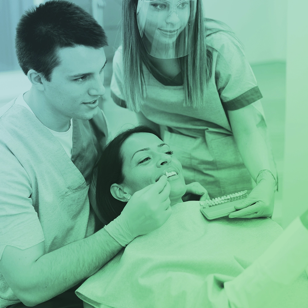 Dentist showing veneers to patient.