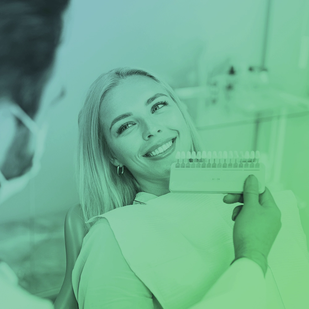Dentist showing veneers to patient.