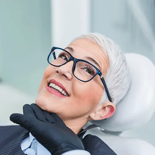 Gloved hand lifting the chin of smiling woman.