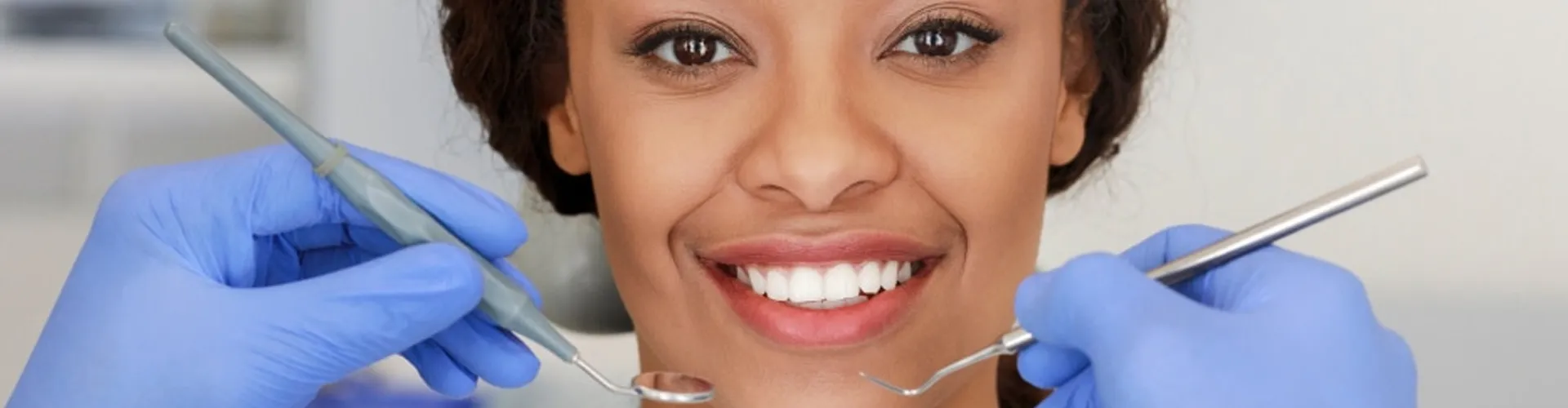 Close-up of a smile surrounded by dental tools.